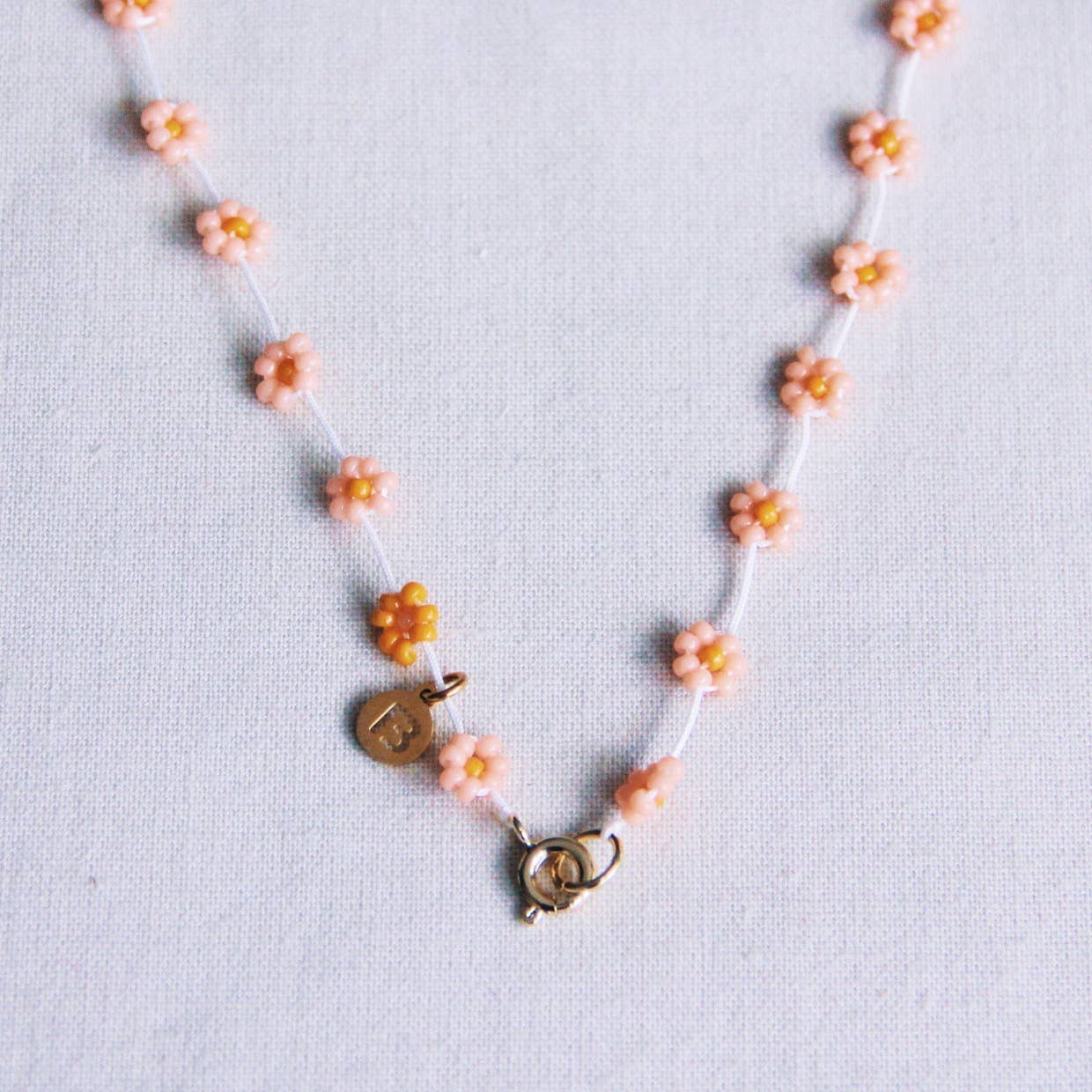 Bazou Collana con fiore di margherita in rosa salmone/arancione