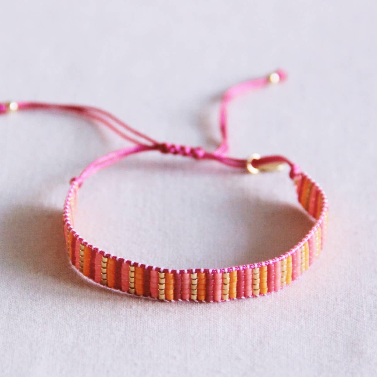 Bazou Bracciale intrecciato a righe - rosa/arancione